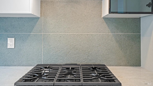 details featuring gas cooktop, white cabinetry, and light countertops