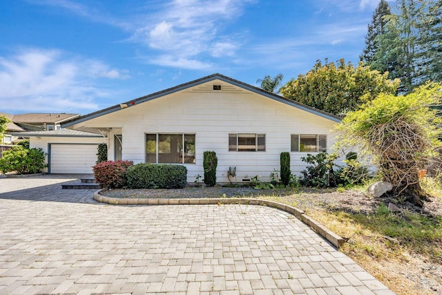view of front of home with a garage and decorative driveway