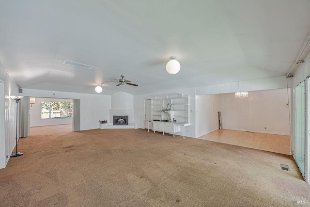 unfurnished living room featuring ceiling fan, carpet floors, lofted ceiling, and a fireplace