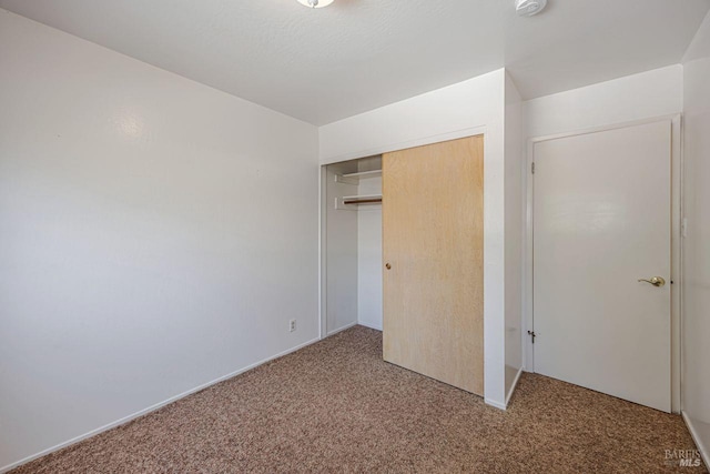 unfurnished bedroom with a closet and carpet flooring