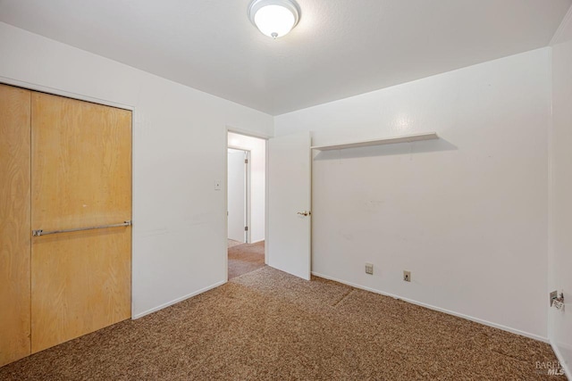 unfurnished bedroom with baseboards, carpet flooring, and a closet
