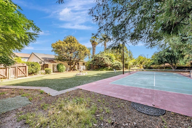 exterior space featuring fence, a yard, and a tennis court