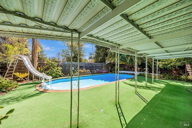 view of pool with a fenced backyard, a water slide, and a fenced in pool
