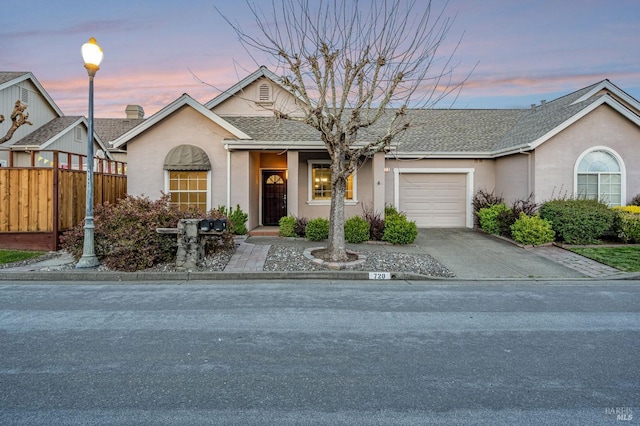 view of front of property with a garage, fence, concrete driveway, stucco siding, and roof with shingles