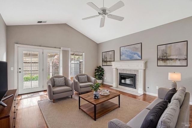 living area featuring light wood-style floors, visible vents, ceiling fan, and lofted ceiling