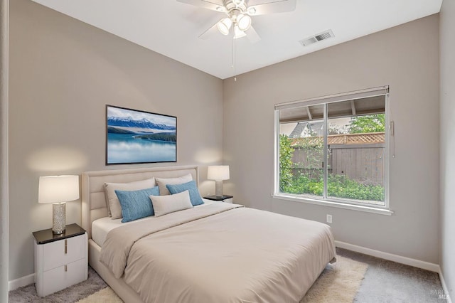 bedroom with light carpet, visible vents, baseboards, and a ceiling fan