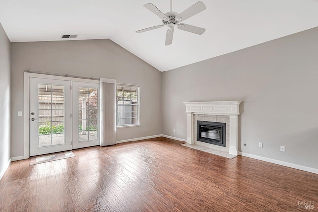 unfurnished living room with visible vents, ceiling fan, wood finished floors, vaulted ceiling, and a tile fireplace