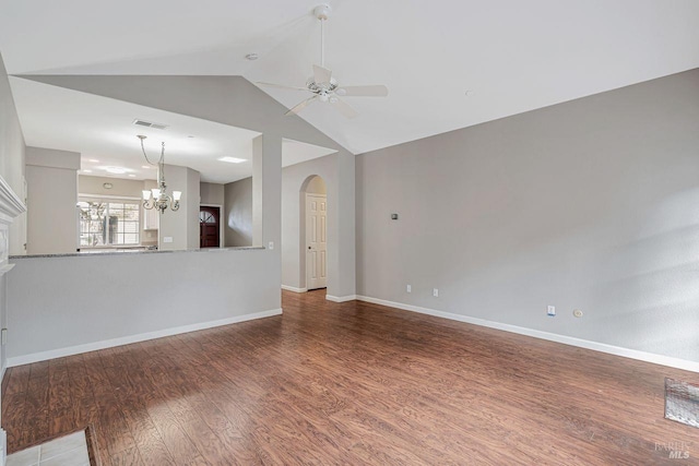 unfurnished living room with ceiling fan with notable chandelier, arched walkways, visible vents, wood finished floors, and lofted ceiling