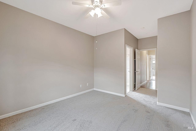 unfurnished room with light colored carpet, baseboards, and a ceiling fan
