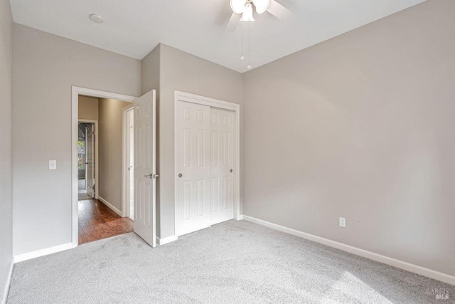 unfurnished bedroom featuring a closet, carpet flooring, baseboards, and ceiling fan