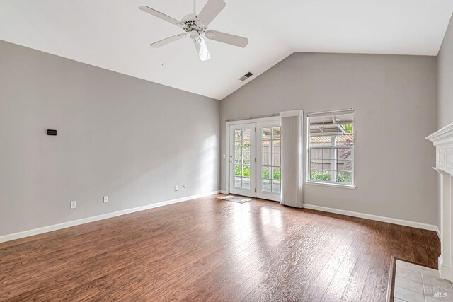 unfurnished living room featuring visible vents, baseboards, ceiling fan, wood finished floors, and high vaulted ceiling