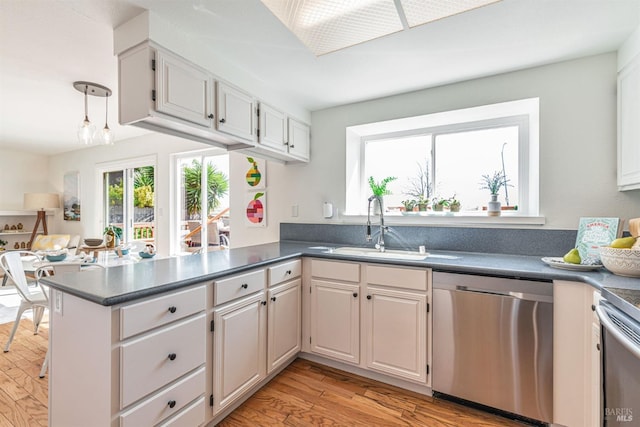 141 Albatrosse Way, Vallejo, CA 94589 - kitchen with dishwasher, a sink, light wood-type flooring, dark countertops, and a peninsula