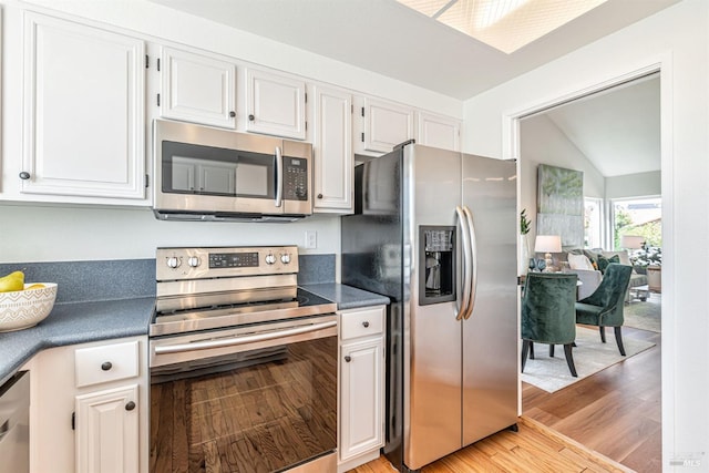 141 Albatrosse Way, Vallejo, CA 94589 - kitchen with white cabinets, appliances with stainless steel finishes, dark countertops, light wood-style flooring, and lofted ceiling