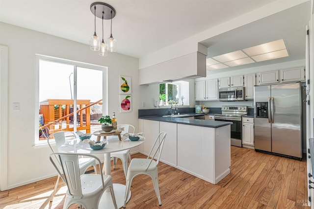 141 Albatrosse Way, Vallejo, CA 94589 - kitchen with a peninsula, dark countertops, stainless steel appliances, light wood finished floors, and a sink
