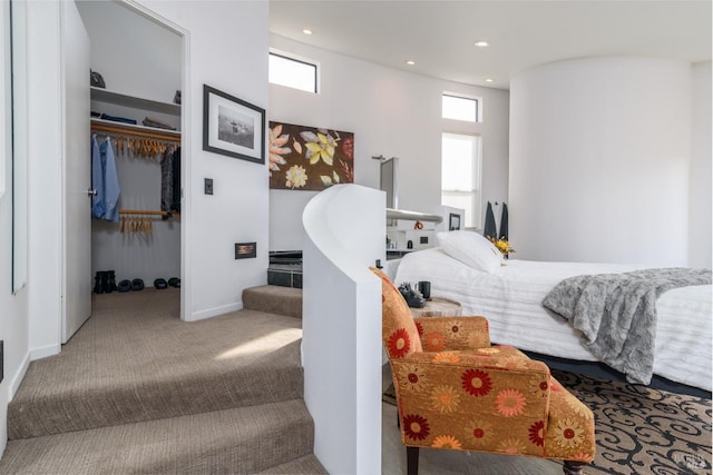bedroom featuring a closet, baseboards, a spacious closet, recessed lighting, and carpet flooring