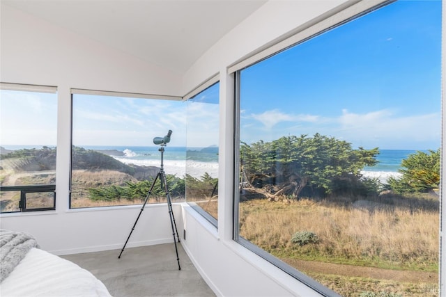 sunroom featuring a water view, baseboards, a beach view, and vaulted ceiling
