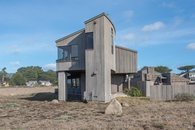 back of property with fence and a balcony