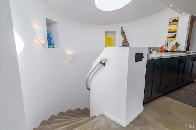 staircase with recessed lighting and finished concrete floors