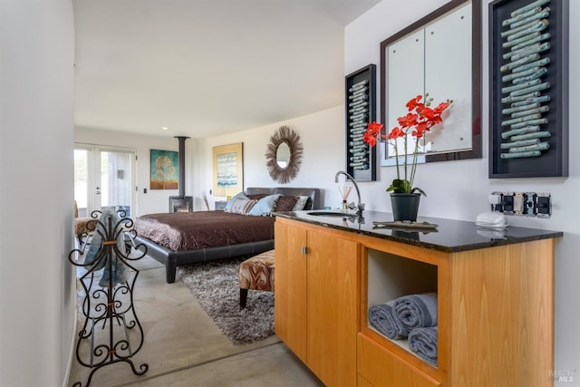 bedroom with finished concrete flooring and a sink