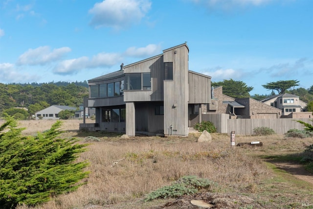rear view of house featuring fence