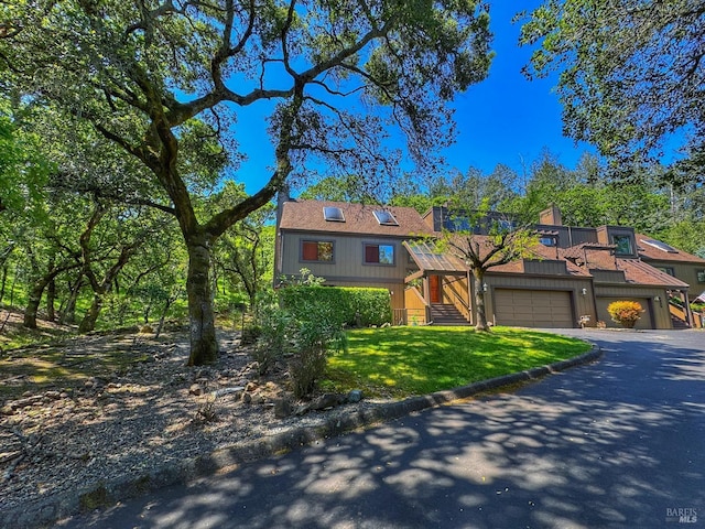 view of front of house with a front lawn, a garage, and aphalt driveway