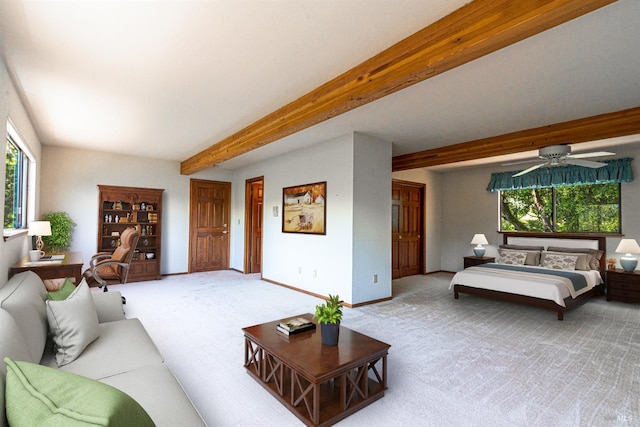 carpeted living area with a wealth of natural light, baseboards, beam ceiling, and ceiling fan