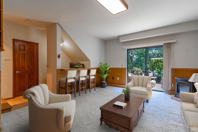 living room with carpet floors, wood walls, and a wainscoted wall