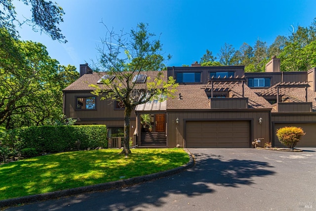 townhome / multi-family property with roof with shingles, central air condition unit, a chimney, a front lawn, and aphalt driveway