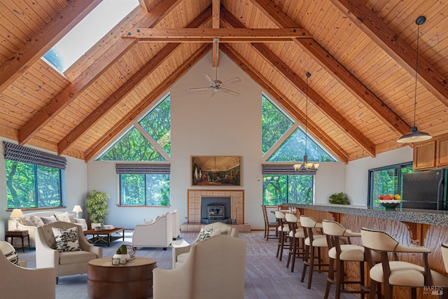 living area with a tiled fireplace, beamed ceiling, high vaulted ceiling, and wooden ceiling
