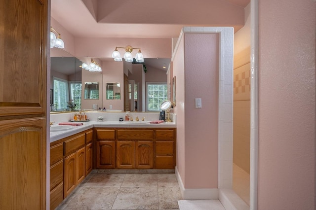 bathroom featuring a sink, double vanity, and a wealth of natural light