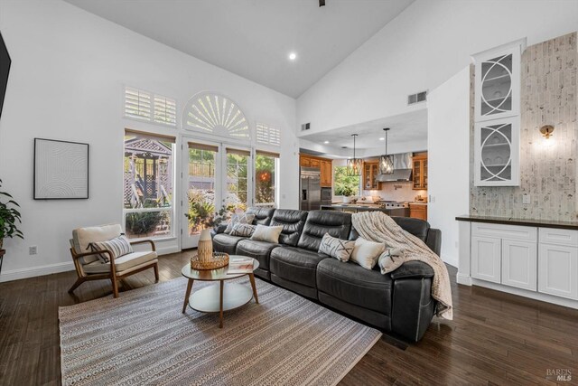 living area featuring baseboards, recessed lighting, dark wood-type flooring, visible vents, and high vaulted ceiling