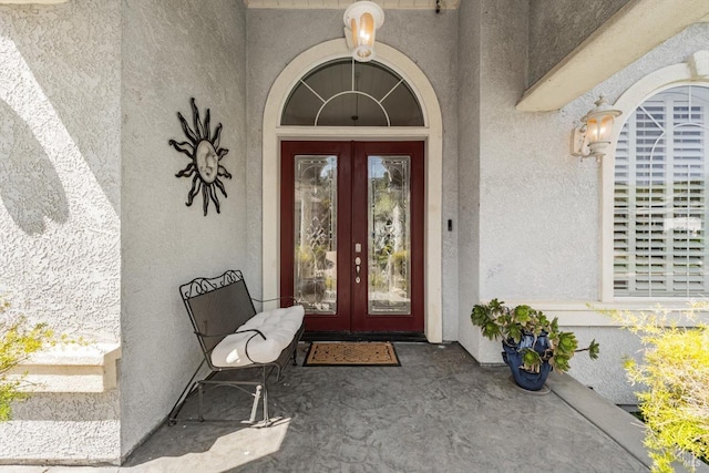 doorway to property featuring french doors and stucco siding