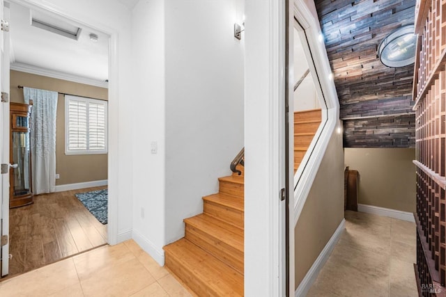 staircase with attic access, baseboards, crown molding, and tile patterned floors