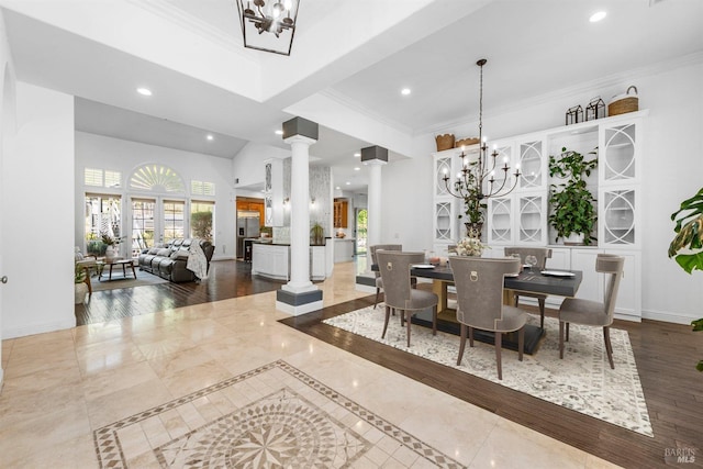 dining space featuring recessed lighting, a notable chandelier, crown molding, and ornate columns