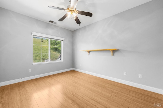 empty room with light wood-style flooring, visible vents, baseboards, and ceiling fan