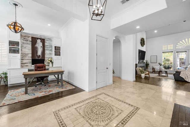 tiled entrance foyer featuring arched walkways, a notable chandelier, ornamental molding, and baseboards