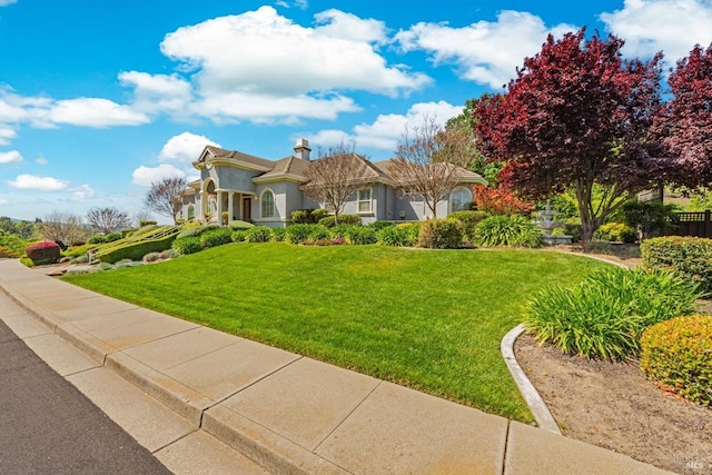 view of front of home with stucco siding and a front lawn
