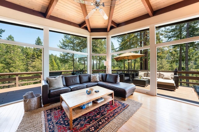 sunroom / solarium with beam ceiling, ceiling fan, and an outdoor living space