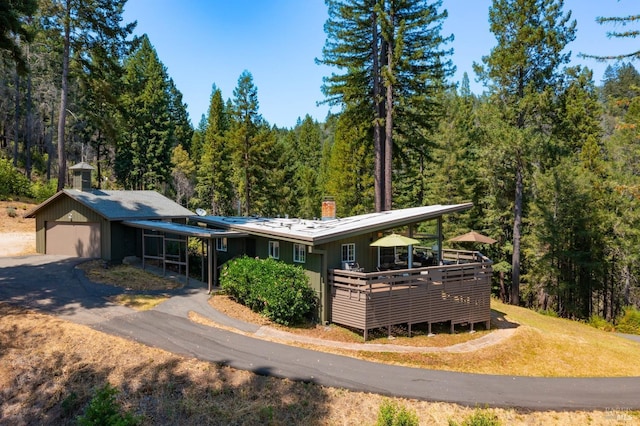 ranch-style home with a view of trees and a chimney