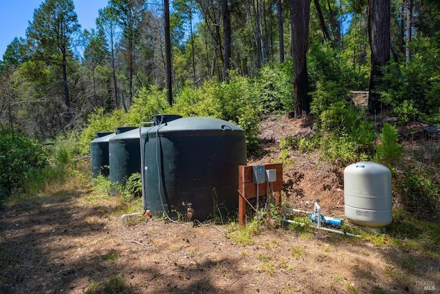 entry to storm shelter featuring a view of trees