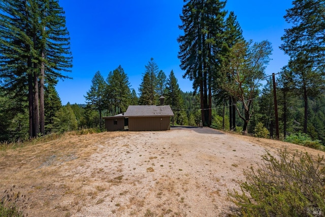 view of yard with a view of trees