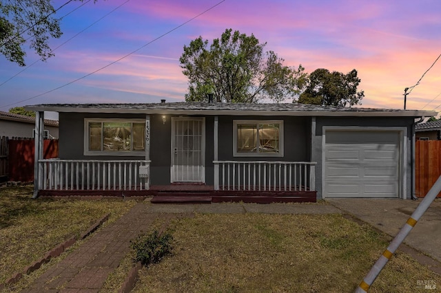 single story home with covered porch, a garage, concrete driveway, fence, and stucco siding