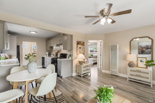 dining room featuring baseboards, a ceiling fan, and wood finished floors