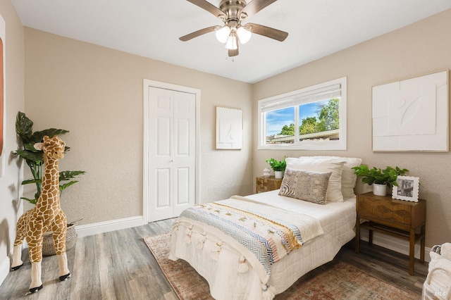 bedroom featuring baseboards, a ceiling fan, wood finished floors, and a closet
