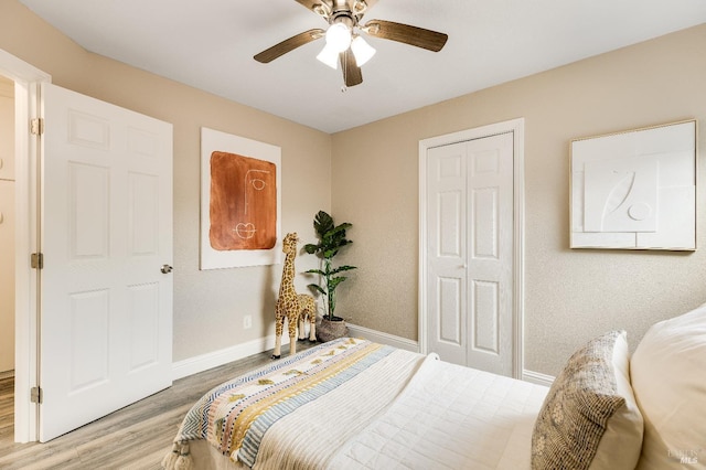 bedroom with light wood-type flooring, a ceiling fan, and baseboards
