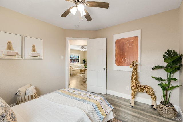 bedroom featuring ceiling fan, baseboards, and wood finished floors