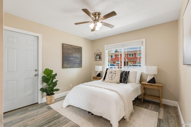 bedroom with wood finished floors, ceiling fan, and baseboards