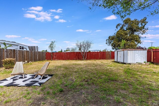 view of yard with a fenced backyard, a shed, and an outdoor structure