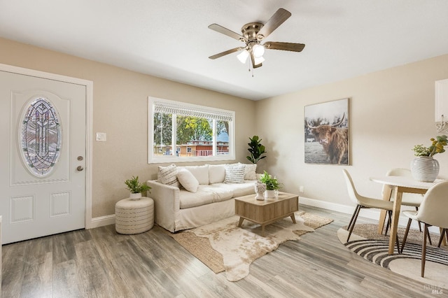 living room with wood finished floors, ceiling fan, and baseboards