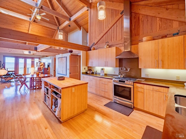kitchen with high vaulted ceiling, wall chimney exhaust hood, gas range, wooden ceiling, and wood counters